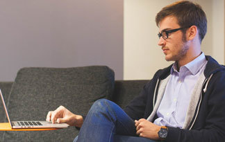 Bild: Mann auf Sofa mit Laptop